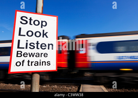 Arrêter de regarder écouter méfiez-vous des trains signe par un excès de train qui passait un signe d'avertissement Angleterre GO UK Europe Banque D'Images