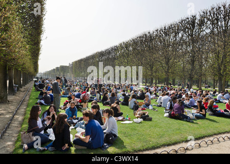 Les élèves prenant le déjeuner sur la pelouse en face du Palais du Luxembourg au début de soleil du printemps, le Jardin du Luxembourg, Paris, France Banque D'Images