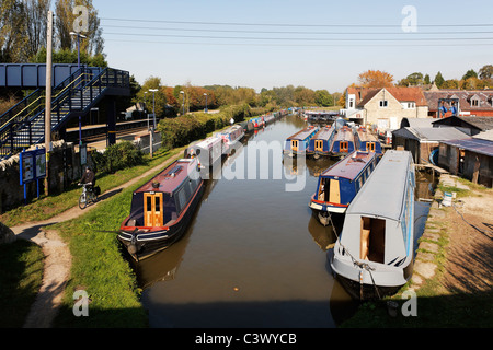 Heyford Wharf Marina Boat Yard avec des dizaines de Canal bateaux amarrés et les marcheurs et cyclistes sur le chemin de halage à côté de la gare Banque D'Images