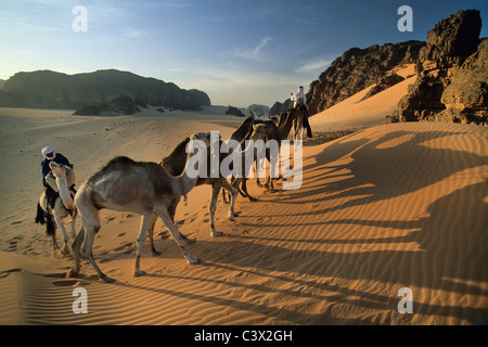 L'Algérie, près de Djanet, les hommes de tribu Touareg et caravanes de chameaux. Désert du Sahara. Banque D'Images