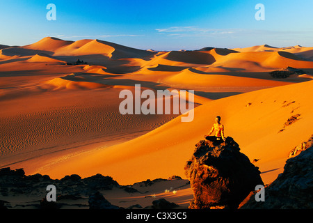 L'Algérie, Djanet. Dunes de sable et de rochers. Femme méditant. Désert du Sahara. Banque D'Images