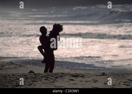 Brésil, Rio de Janeiro, la plage de Copacabana, Couple bénéficiant d'un l'autre au coucher du soleil. Banque D'Images