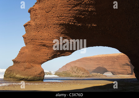 Rock arches sur la plage de Legzira sur l'océan Atlantique, 11 km au nord de la ville de Sidi Ifni, dans le sud-ouest du Maroc. Banque D'Images