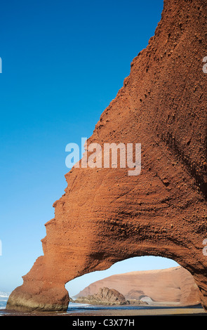 Rock arches sur la plage de Legzira sur l'océan Atlantique, 11 km au nord de la ville de Sidi Ifni, dans le sud-ouest du Maroc. Banque D'Images