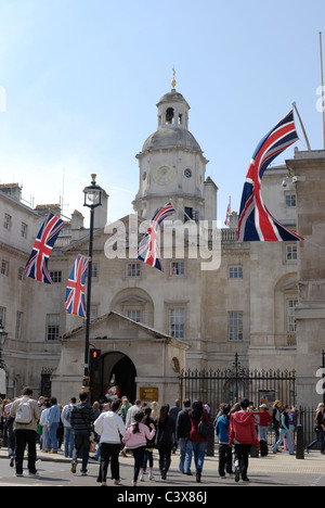 L'Angleterre, Londres, Whitehall. Des foules de touristes à l'extérieur entrée de Horse Guards Parade. Drapeaux de l'Union de mariage royal Banque D'Images