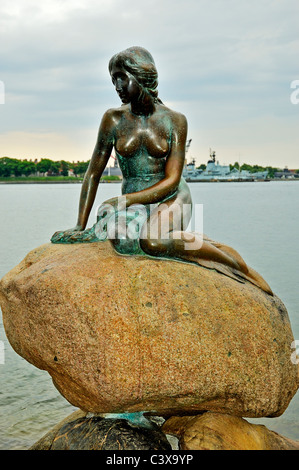 La sculpture de bronze de la Petite Sirène est assis sur un gros rocher près de la rive par le navire de croisière Harbor, Copenhague Banque D'Images