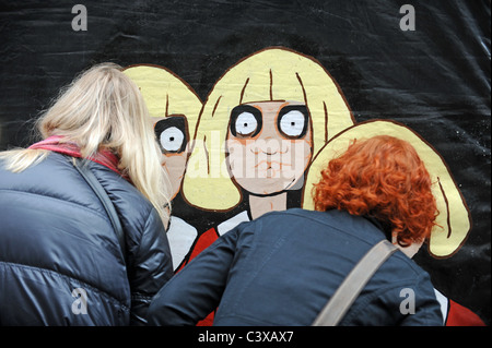 Les membres du public prendre je peep dans l'une des tentes de rendement à Brighton Festival Fringe 2011 rue manifestation UK Banque D'Images