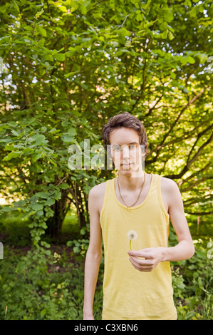 Young man holding dandelion Banque D'Images