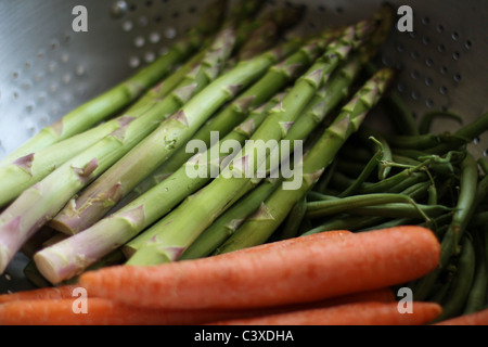 Un gros plan de légumes colorés dans une passoire. Banque D'Images