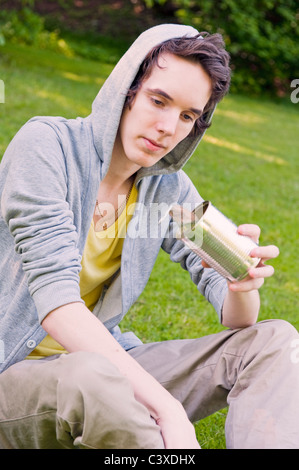 Jeune homme tenant un vieux peut Banque D'Images