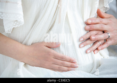Les mains sur le ventre de femme enceinte Banque D'Images