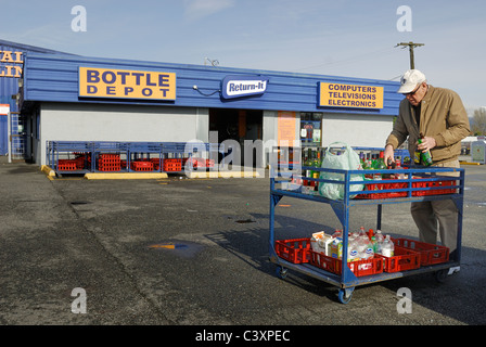 L'organisation de l'homme ses bouteilles sur un panier avant de les prendre dans l'un des nombreux dépôts de bouteilles dans la ville de Vancouver. Banque D'Images