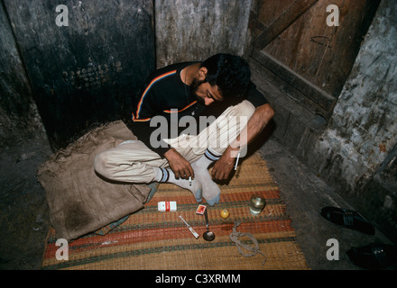 Toxicomane indiens passés avec aiguille encore dans ses bras après avoir lui-même l'injection élevé avec l'héroïne. Bombay, Inde. Banque D'Images