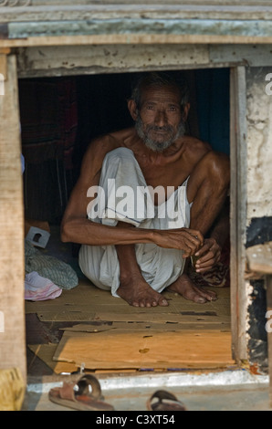 Un homme est assis dans un bateau sur la rivière Buriganga dans Old Dhaka. Banque D'Images