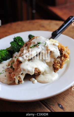 Manger des aliments steak frit au poulet et brocoli avec sauce blanche sur le dessus Banque D'Images