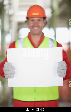 Travailleur ayant une feuille de papier vide Banque D'Images