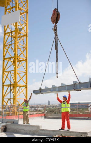 Grue et travailleurs sur site de construction Banque D'Images