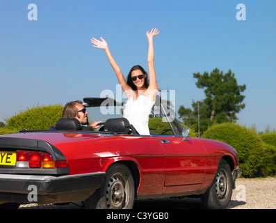 Couple marié fraîchement en voiture, au revoir Banque D'Images