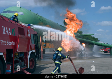 Pompiers de l'aéroport s'attaquer à une simulation d'incendie de moteur sur un avion. Banque D'Images