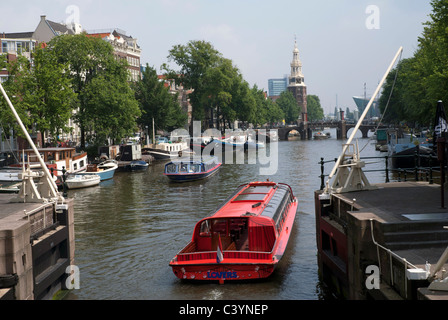 Un bateau de tourisme rouge sur l'Oude Schans Canal à Amsterdam, Pays-Bas Banque D'Images