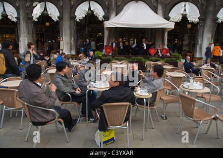 Groupe d'hommes d'origine asiatique bénéficiant du café et de la musique au Café Florian sur la Place Saint Marc Venise Italie Europe centrale Banque D'Images