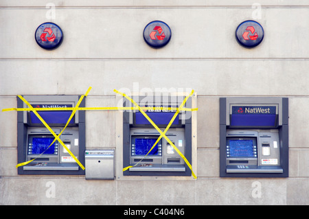 Direction générale de la banque NatWest externes locaux piscine distributeur automatique de billets, deux d'ordre couvert de ruban adhésif jaune une machine travaillant London England UK Banque D'Images