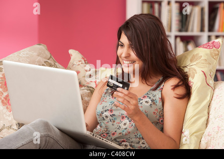 Jeune femme avec carte de crédit à l'ordinateur portable Banque D'Images