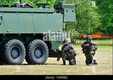 Les soldats d'infanterie tirant près de Mowag Piranha IIIC véhicule blindé de combat pendant l'exercice de l'armée belge, Belgique Banque D'Images