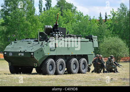 Les soldats d'infanterie belge tirant près de Mowag Piranha IIIC véhicule blindé de combat pendant l'exercice, Belgique Banque D'Images