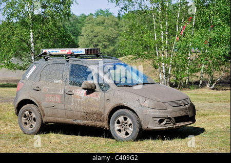 Suzuki SX4 quatre roues motrices véhicule hors route couvert de boue après course cross-country rallye Banque D'Images