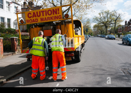 Les travailleurs de la Voirie Alexander UK marquant les lignes jaunes et de places de stationnement. Banque D'Images