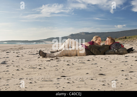 Les jeunes backpackers lying on beach Banque D'Images