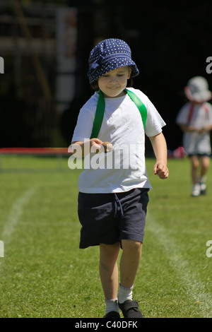 Jeune fille en concurrence dans l'oeuf et la cuillère sur course sportsday Banque D'Images