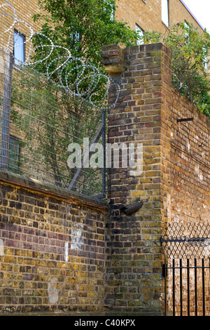 London Kings Cross , clôtures de sécurité , surmontée de barbelés et spike fer forgé recouvert de filet de sécurité canada brick wall Banque D'Images