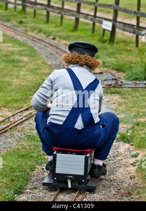 Une femme assise sur un train à vapeur miniature moteur. Banque D'Images