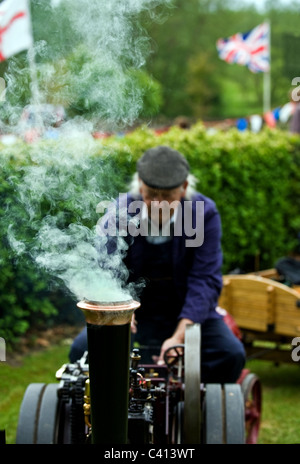 Un homme au volant d'une traction à vapeur miniature à un bain à vapeur juste. Banque D'Images