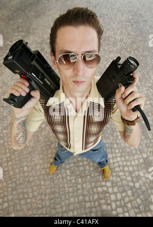 High angle portrait of man holding vieilles caméras super-8 Banque D'Images