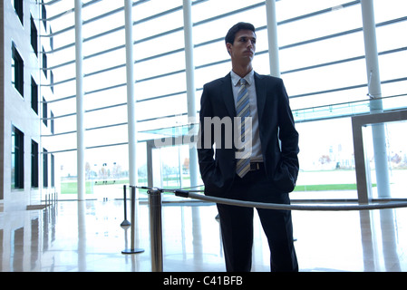 Businessman standing in lobby Banque D'Images