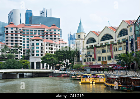 Swissotel Merchant Court avec le gratte-ciel derrière et bateaux sur la rivière près de Clarke Quay Singapour République de Singapour Banque D'Images