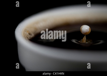 Chute de lait dans la tasse de café Banque D'Images