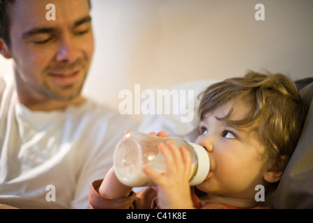 Bébé garçon avec père, boire du lait à partir de bouteille de bébé Banque D'Images