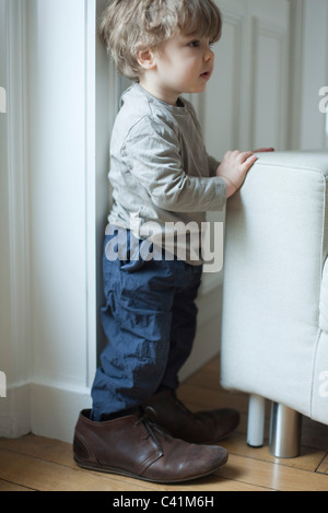 Bébé garçon en chaussures du père, portrait Banque D'Images