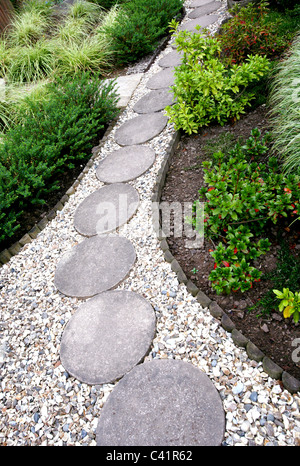 Un jardin de gravier chemin avec stepping stones ronde Banque D'Images