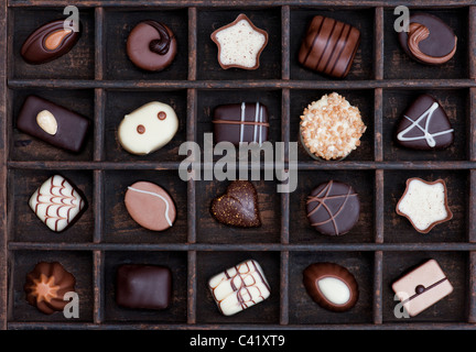 Chocolats Assortis dans un bac en bois motif doux Banque D'Images