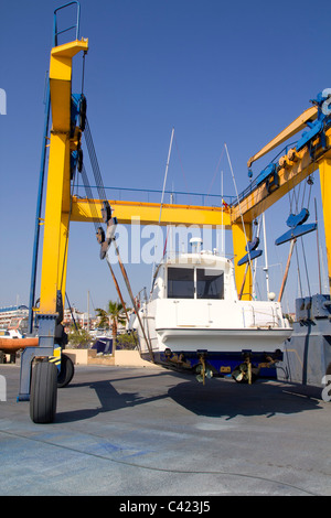 Grue jaune Bateau Bateau à moteur de levage levage voyage annuel pour le traitement de la coque antifouling Banque D'Images