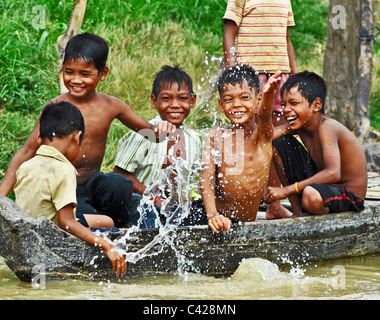 Les enfants cambodgiens jouant dans un bateau à Kompong Khleang, village du lac Tonle Sap, Cambodge Banque D'Images