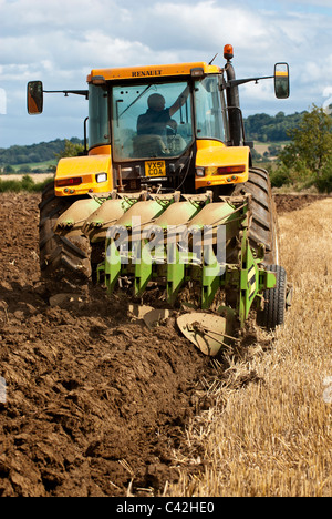 Tracteur Renault laboure un champ après la récolte est terminée Banque D'Images