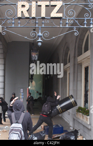 Un groupe de jeunes gens masqués habillés comme des anarchistes et vandaliser l'attaque de l'hôtel Ritz sur Piccadilly, Londres Banque D'Images