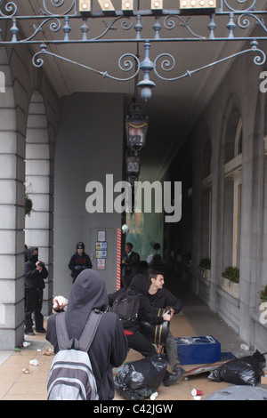 Un groupe de jeunes gens masqués habillés comme des anarchistes et vandaliser l'attaque de l'hôtel Ritz sur Piccadilly, Londres Banque D'Images