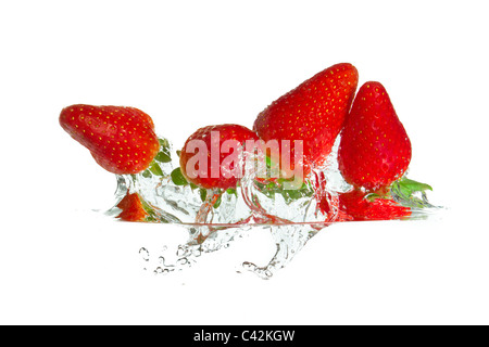 Des fraises fraîches est tombé dans l'eau avec splash sur fonds blancs Banque D'Images